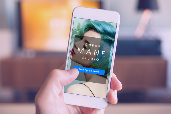 women at home booking a hair appointment on mobile phone